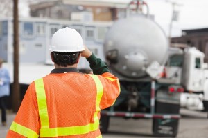Environmental engineer directing tanker truck for hazardous waste cleanup